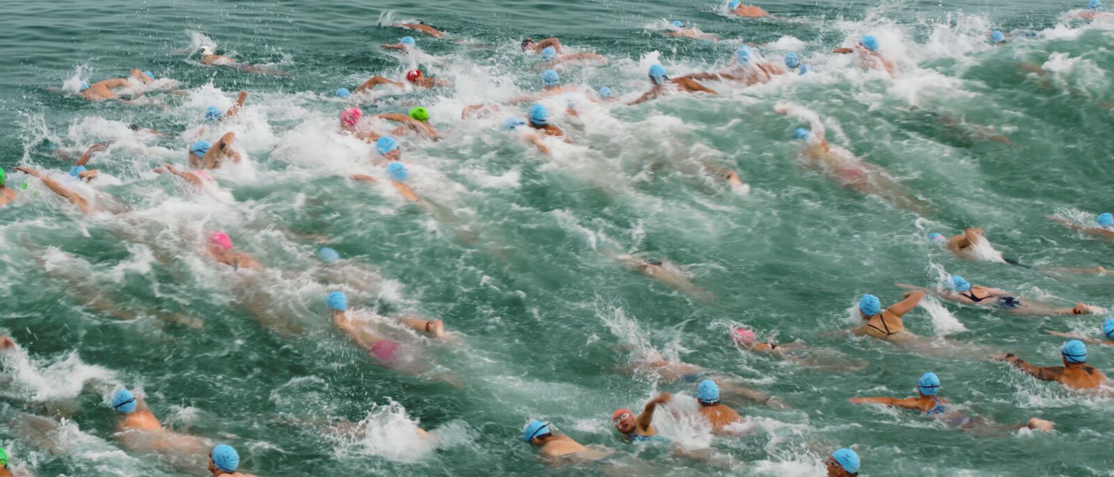 Open-water swim race from above — aerial still from the Woodson reel