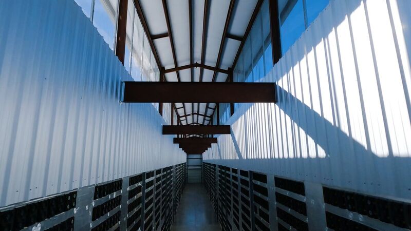 FPV frame inside an industrial corridor, steel and skylights overhead