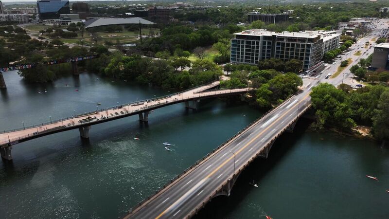 Pedestrian bridge and paddlers on Lady Bird Lake from the air